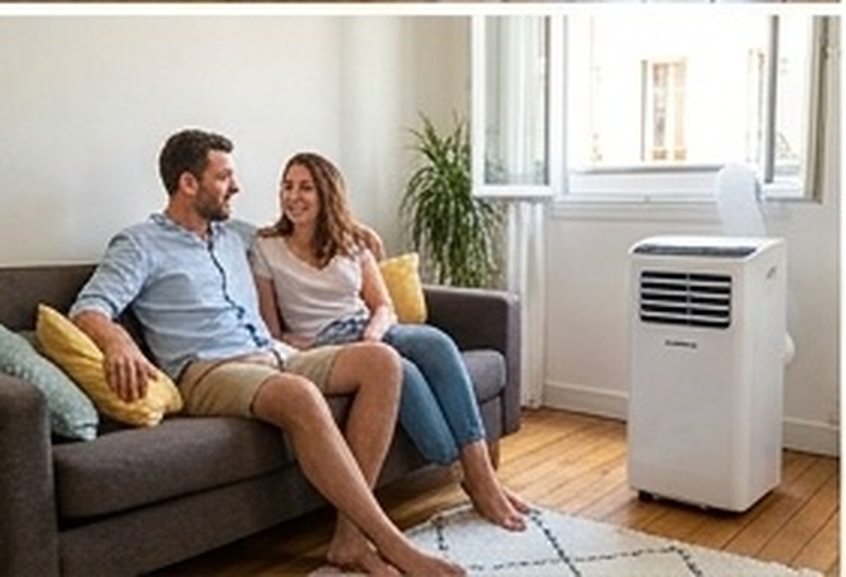 Couple installé dans un salon rafraîchi par un climatiseur mobile en location